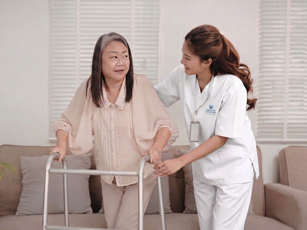 A trained GLC Hire caregiver helping an elderly stroke survivor walk with a frame at home